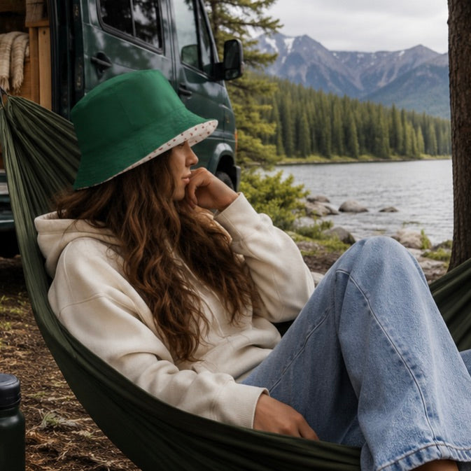 Wendbarer Bucket Hat Forest Dots mit cremefarbenem Stoff, dunkelrotem Punktemuster und einer schlichten dunkelgrünen Rückseite.