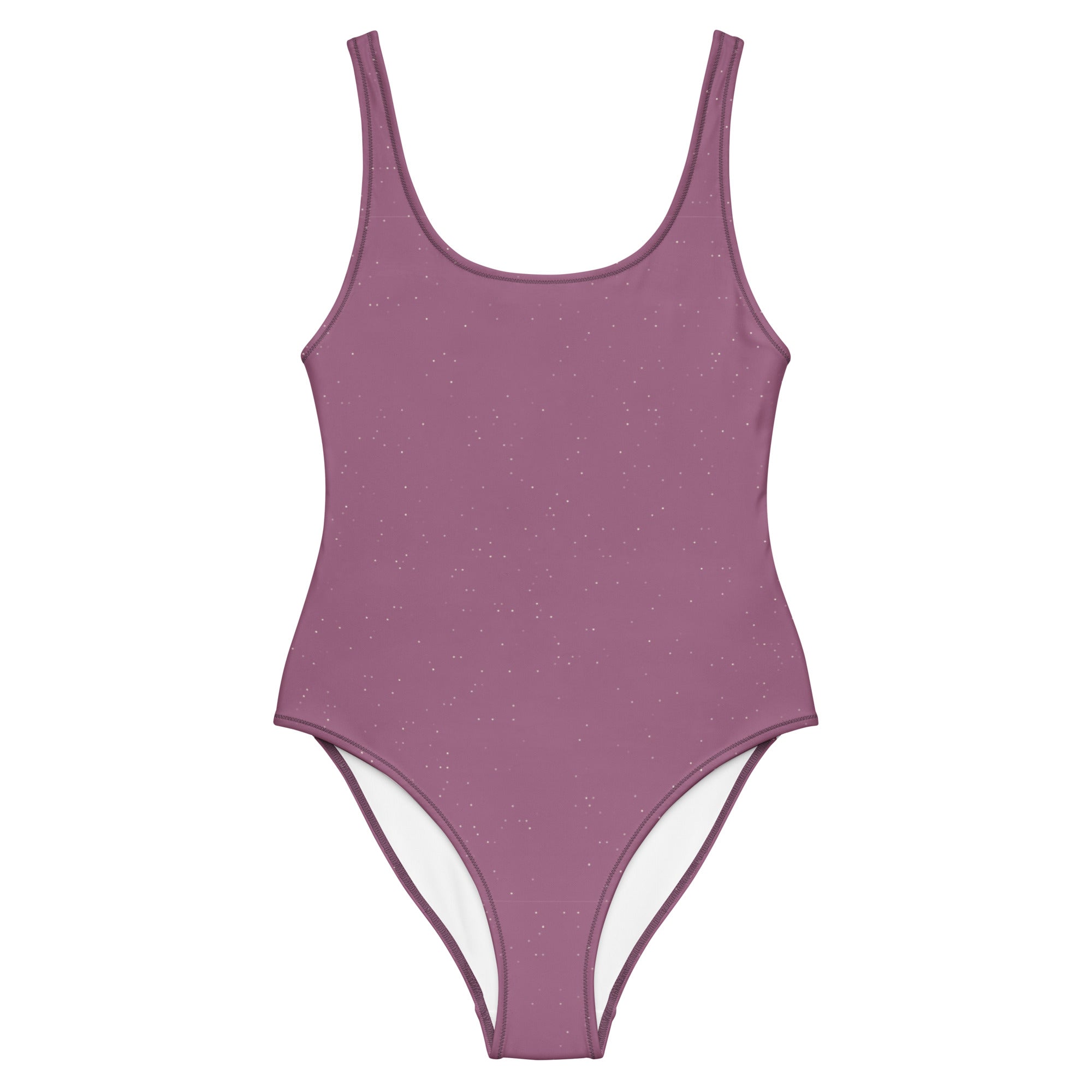 Mauvefarbener Damenbadeanzug Mauve Stardust mit Rundhalsausschnitt, breiten Trägern und dezenten Glitzerakzenten, präsentiert vor türkisblauem Meer und einer mediterranen Steinterrasse mit roten Rosen.