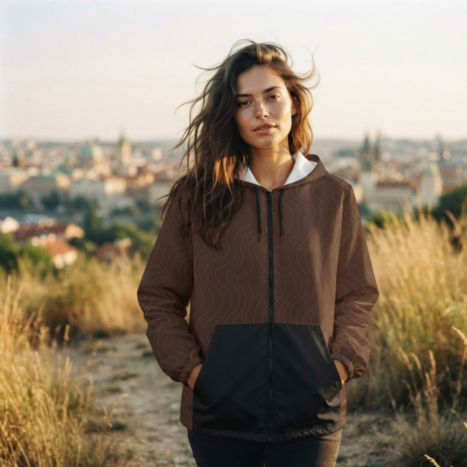 Brauner Windbreaker Mocha Waves für Damen mit Wellenmuster, Kapuze und schwarzer Fronttaschen.