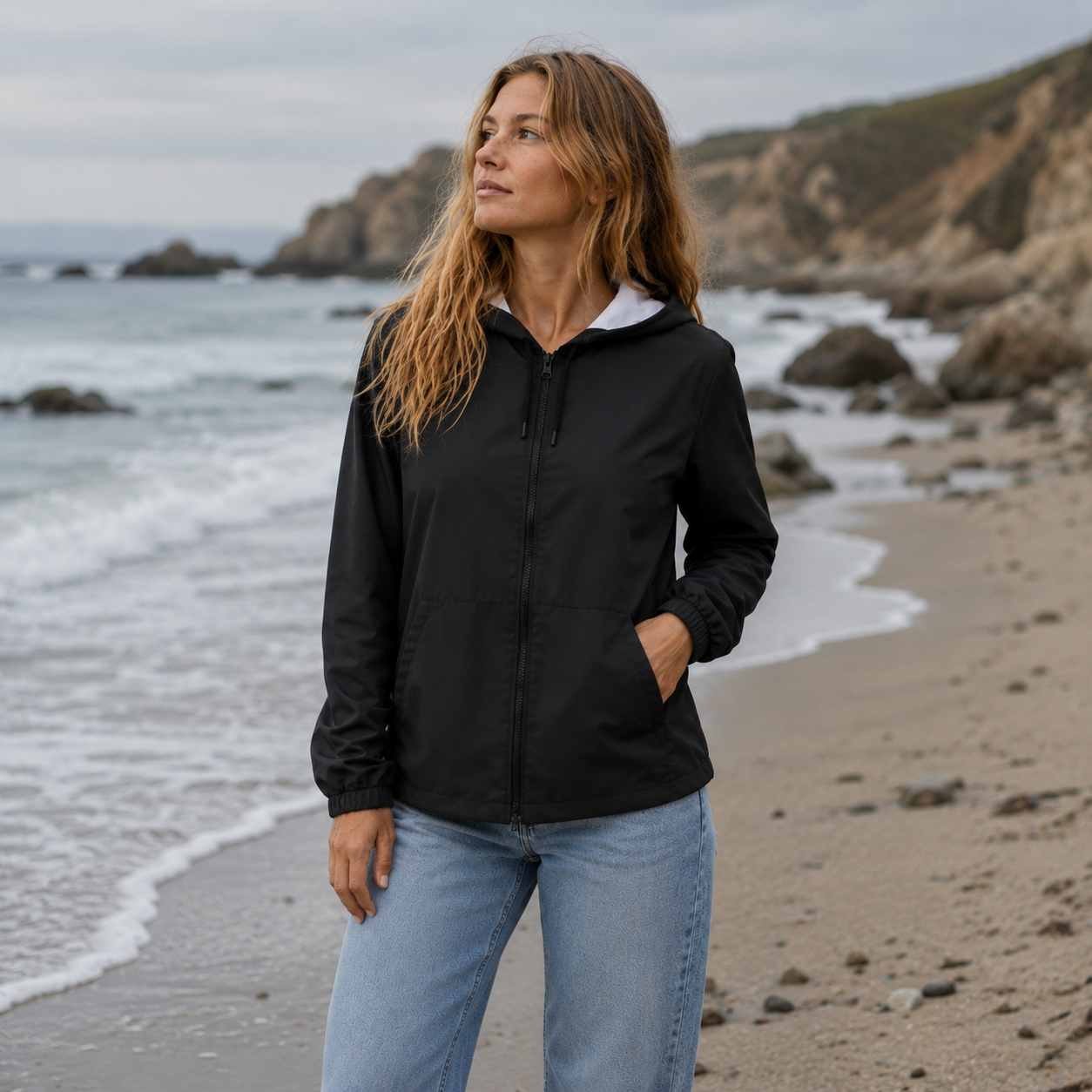 Schwarzer Windbreaker für Damen mit Kapuze, schwarzem Reißverschluss und großen Taschen.